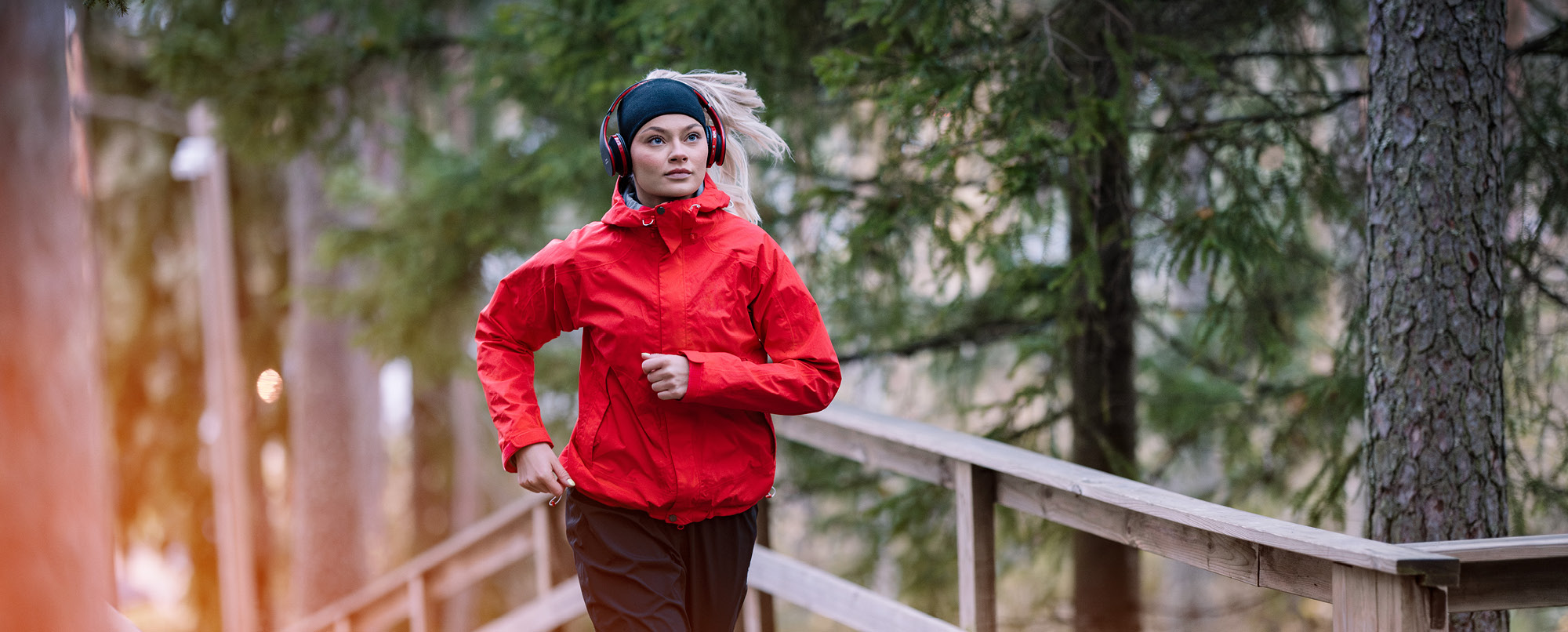 Nainen juoksee ja kuuntelee kuulokkeilla Ilkka-Pohjalaisen podcastia